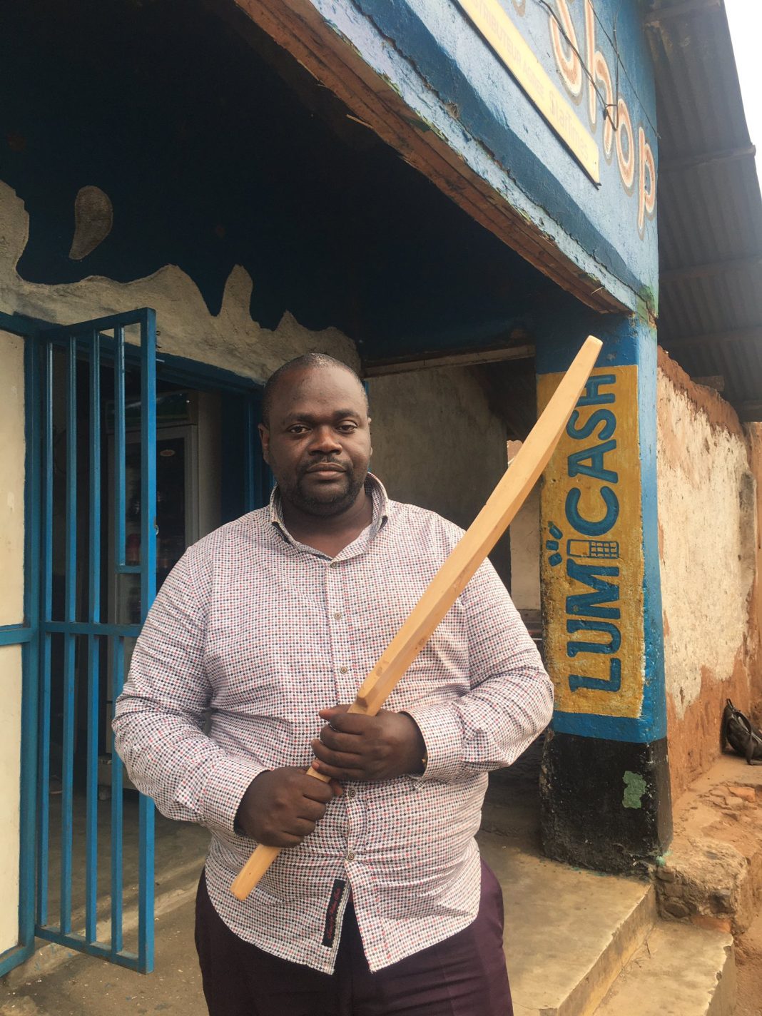 Burundi Cricket Federation President John-Clinton Nsengiyumva with a bat